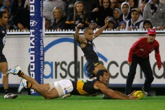 Alex Rance of Richmond rushes the ball through for a behind ahead of Jeffrey Garlett of Carlton during the AFL Round 01 match between Carlton Blues and the Richmond Tigers at the MCG, Melbourne.